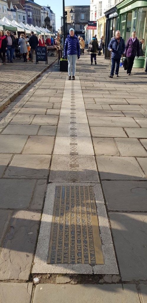 There is a plaque commemorating the world record long jump (6.76 metres) by Rand at the 1964 Olympic Games in the Market Place in Wells.